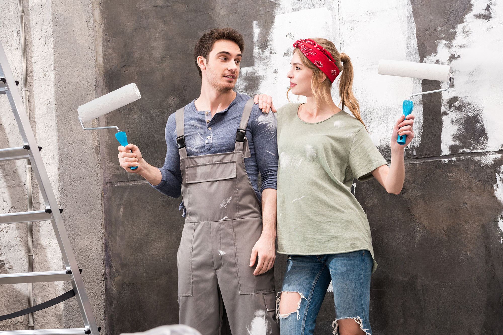 Young Couple painting with rollers as part of a renovation